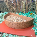 Curved brick wall hamster dig box filled with substrate