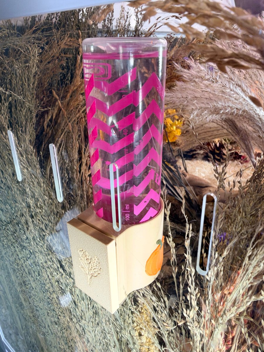 Side view of magnetic pumpkin hamster water bottle holder with water bottle